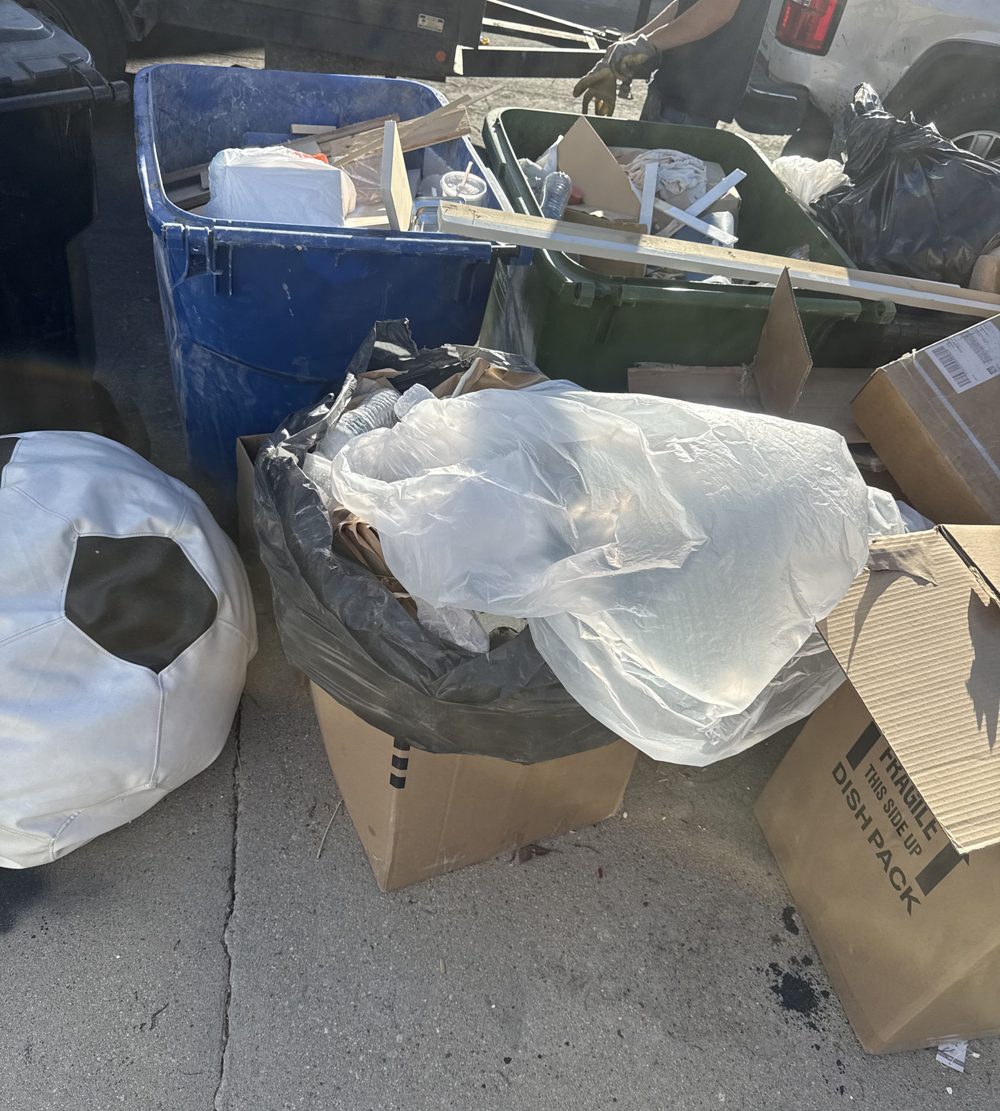 Overflowing bin and bags of household junk