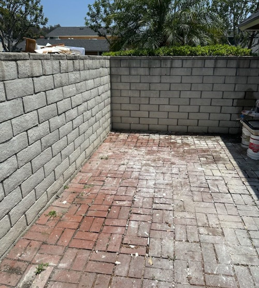 Brick patio cleared and swept after a backyard removal job