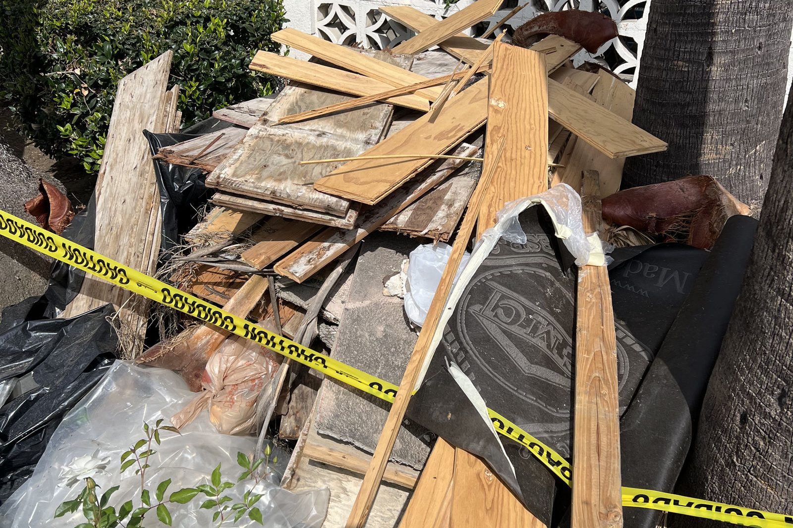 Pile of construction lumber and debris behind a home