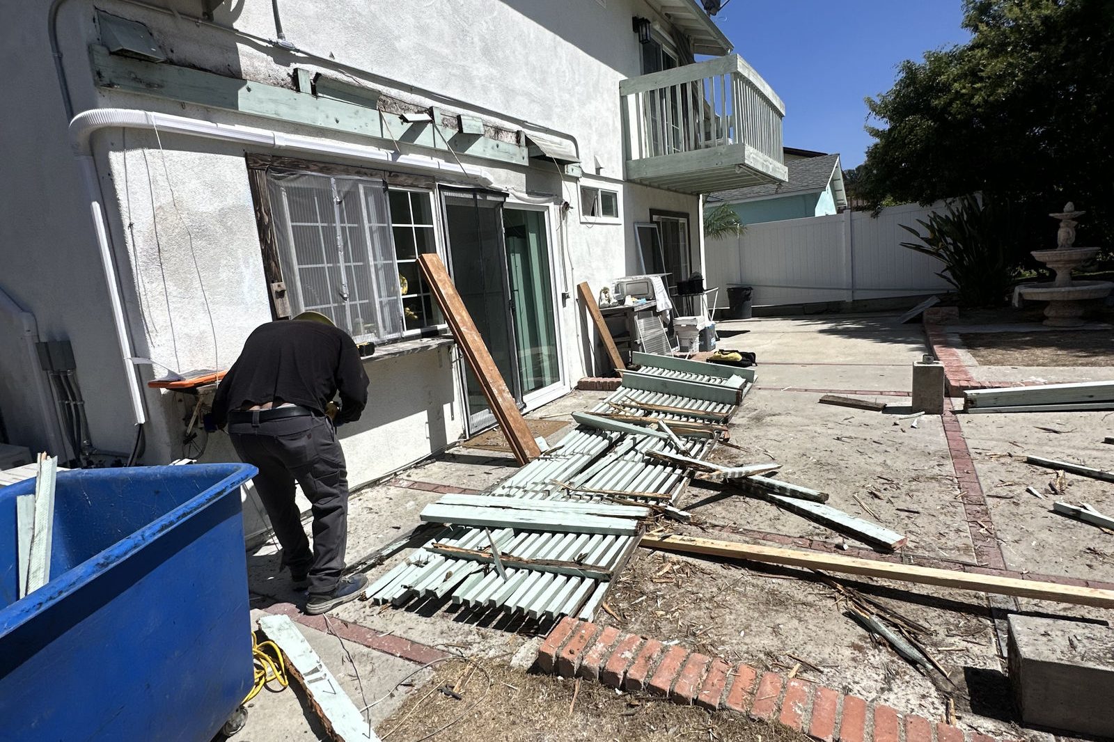Demolition debris next to a dumpster while the crew works on site