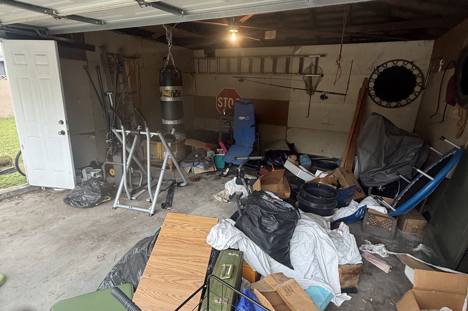Cluttered garage packed with boxes and household items before a cleanout