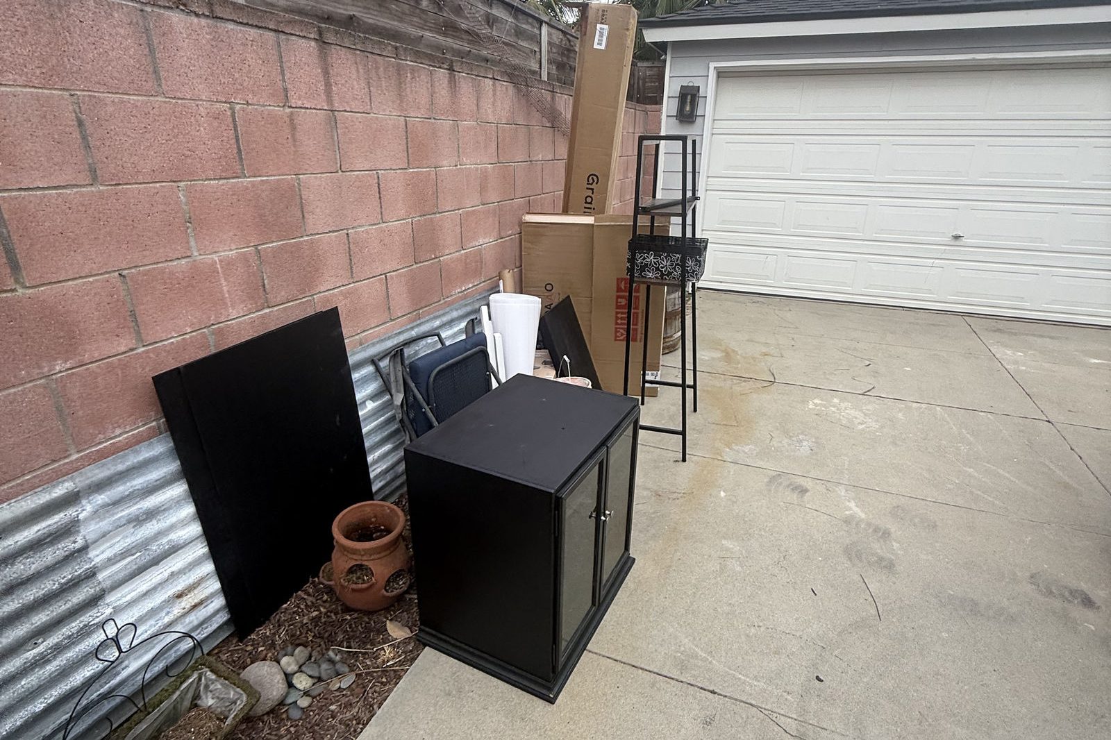 Old TV and small appliances left beside a garage for removal